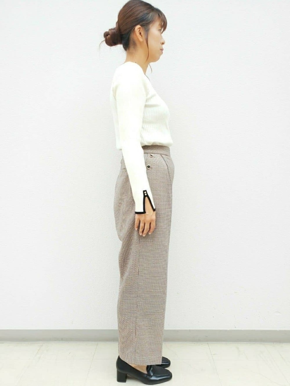 ベージュ系のニット/セーター、ブラウン系のその他パンツ、グレー系のショルダーバッグを着用したレディースの秋コーディネートの2枚目の写真