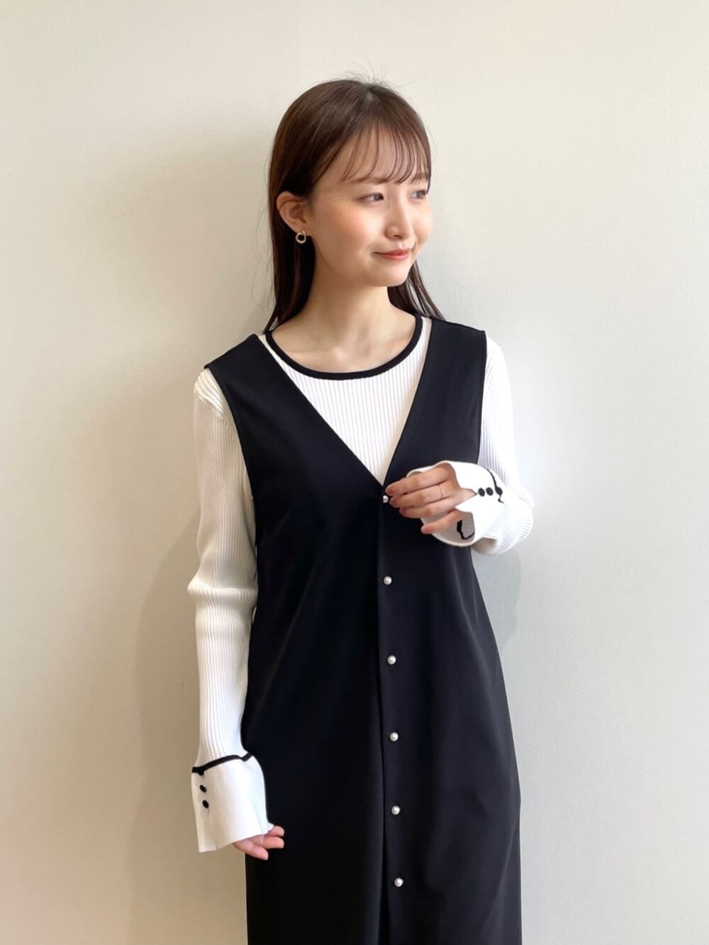 ホワイト系のニット/セーター、ブラック系のスカート、ブラック系のその他シューズを着用したレディースの春コーディネートの5枚目の写真