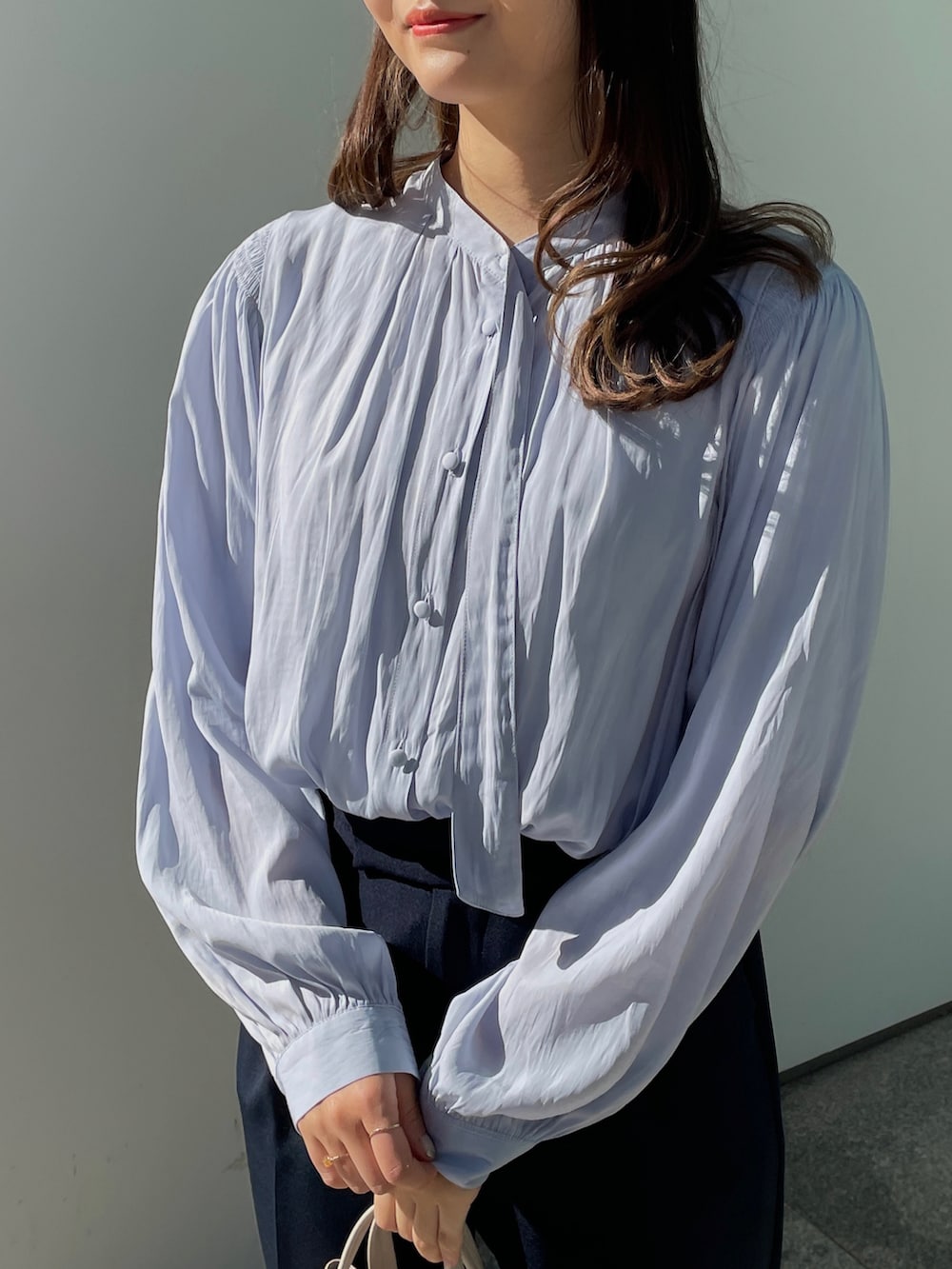 ブルー系のスーツパンツ、ブルー系のシャツ/ブラウス、ベージュ系のショルダーバッグを着用したレディースの冬コーディネートの2枚目の写真