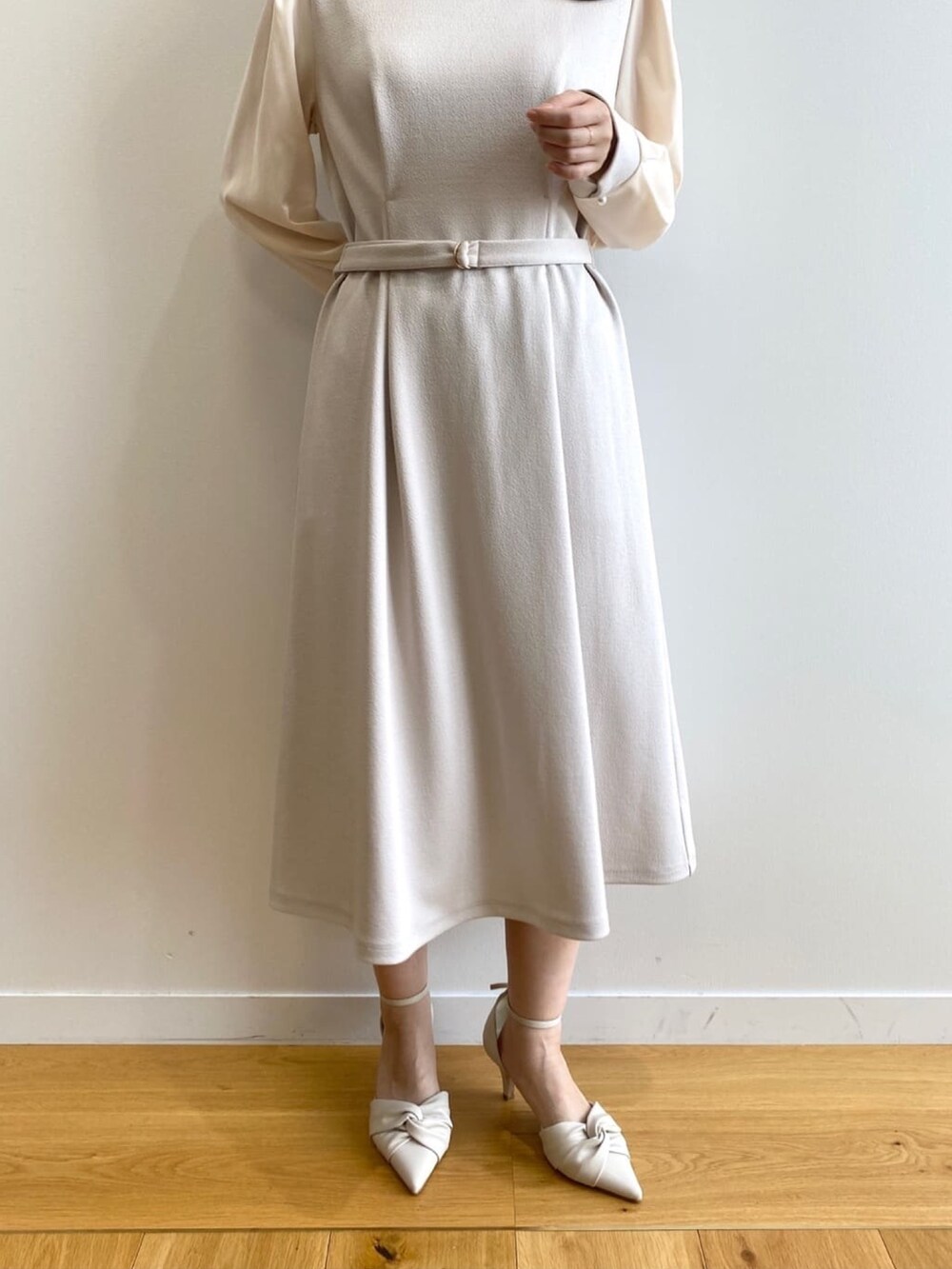 ベージュ系のワンピース、ホワイト系のパンプスを着用したレディースの冬コーディネートの7枚目の写真