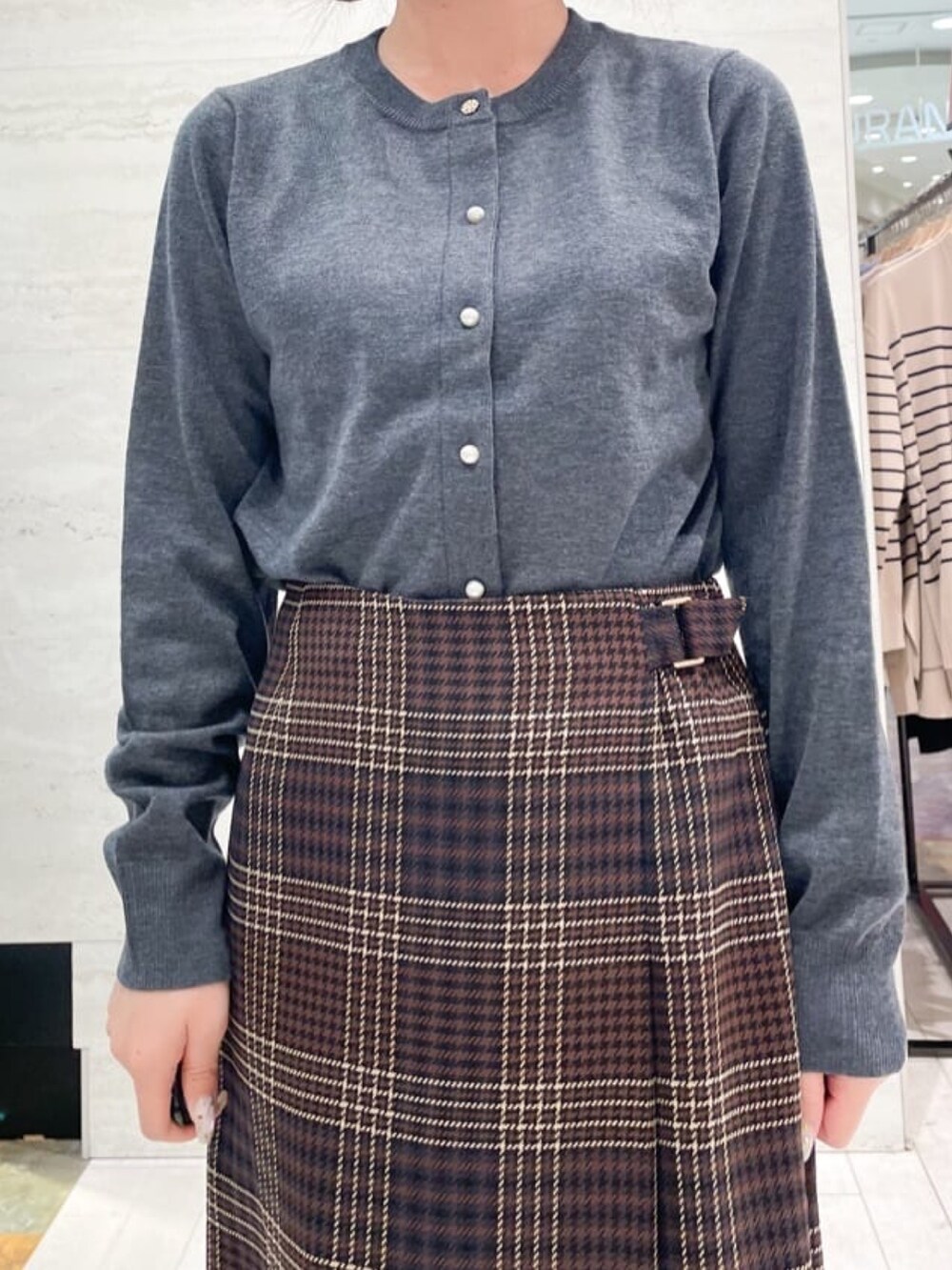 グレー系のカーディガン/ボレロ、ブラウン系のスカート、グレー系のショルダーバッグを着用したレディースの秋コーディネートの2枚目の写真