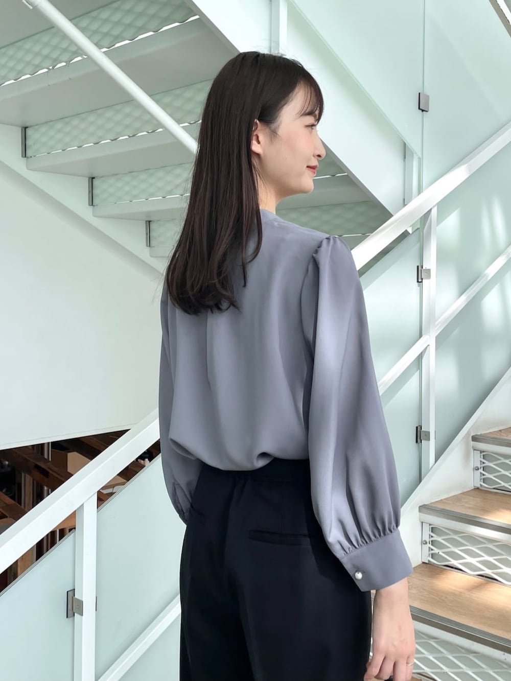 グレー系のシャツ/ブラウス、ブラック系のその他パンツ、ホワイト系のパンプスを着用したレディースの春コーディネートの4枚目の写真