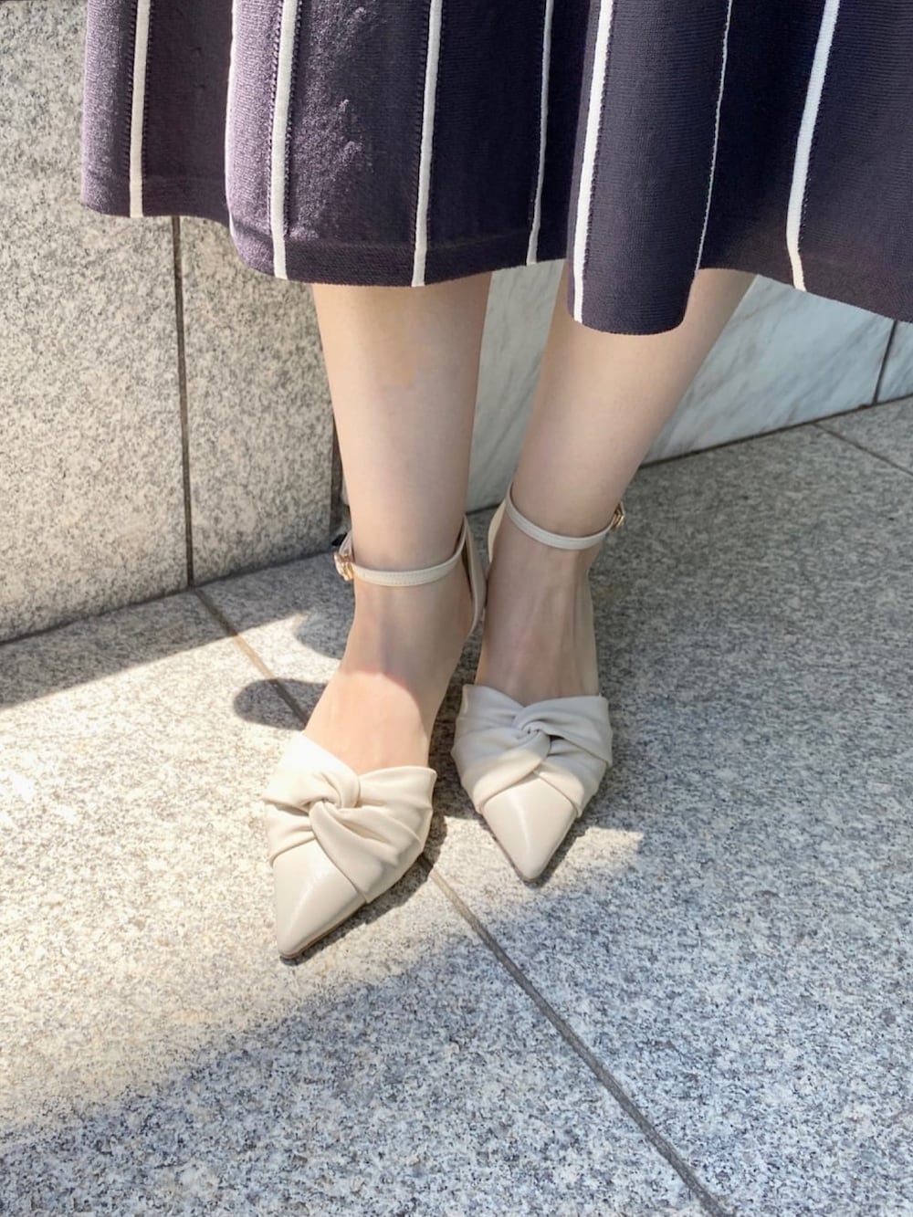 グレー系のワンピース、ホワイト系のパンプス、グレー系のトートバッグを着用したレディースの夏コーディネートの7枚目の写真