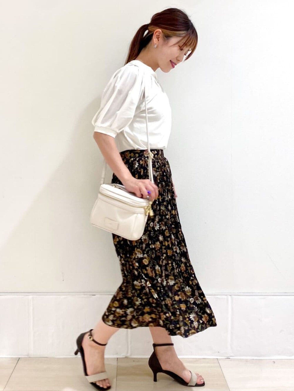 ホワイト系のショルダーバッグ、ブラック系のスカート、ベージュ系のサンダルを着用したレディースの夏コーディネートの4枚目の写真