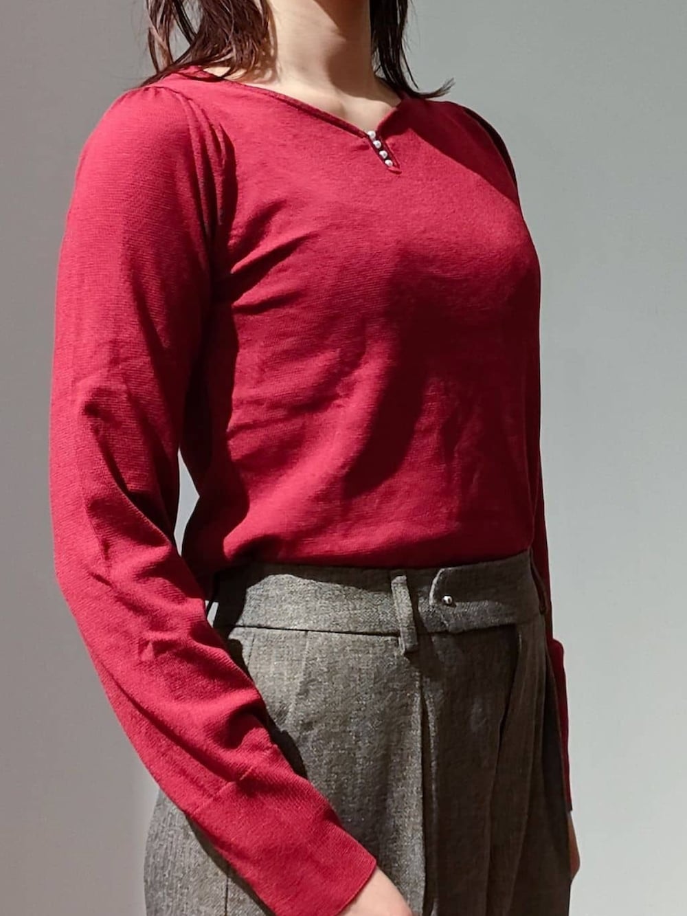 レッド系のニット/セーター、ブラウン系のその他パンツ、ブラック系のショルダーバッグを着用したレディースの秋コーディネートの4枚目の写真