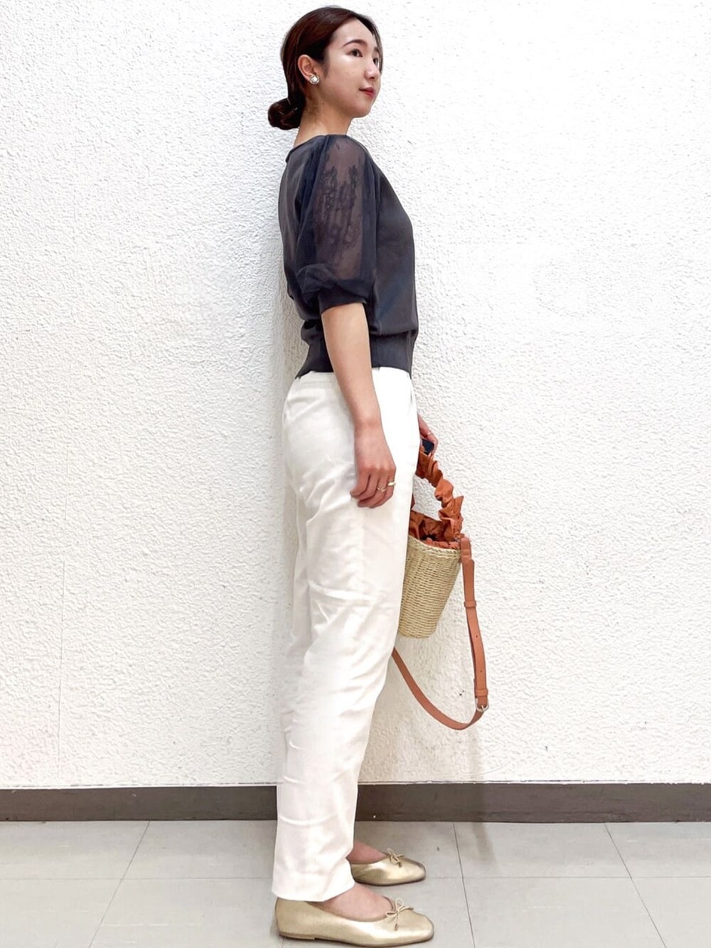 グレー系のニット/セーター、ホワイト系のその他パンツ、オレンジ系のショルダーバッグを着用したレディースの夏コーディネートの2枚目の写真