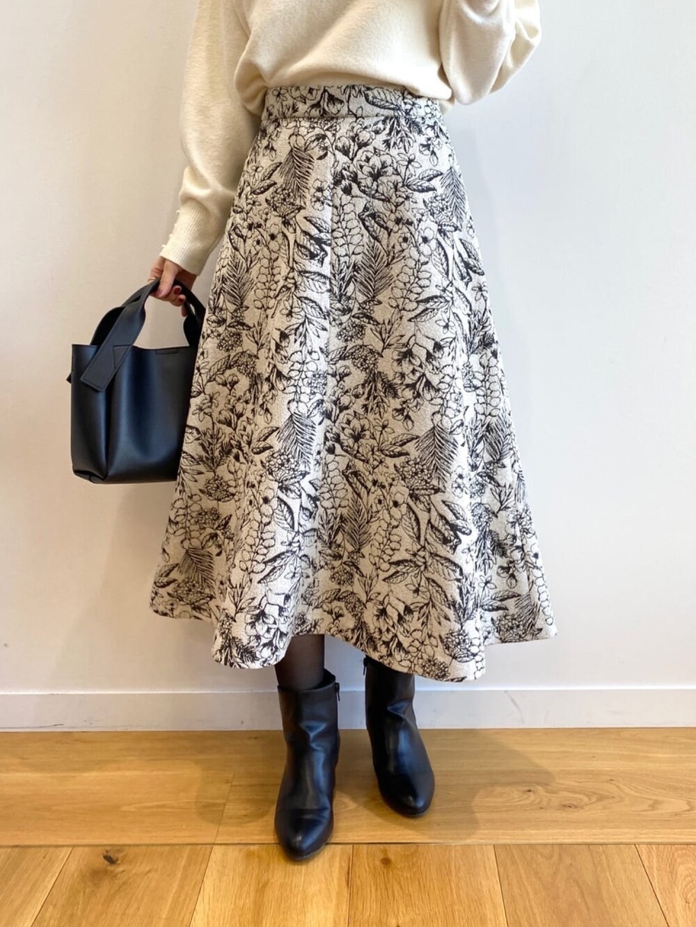 ホワイト系のニット/セーター、ブラック系のショルダーバッグ、ブラック系のブーツを着用したレディースの冬コーディネートの7枚目の写真