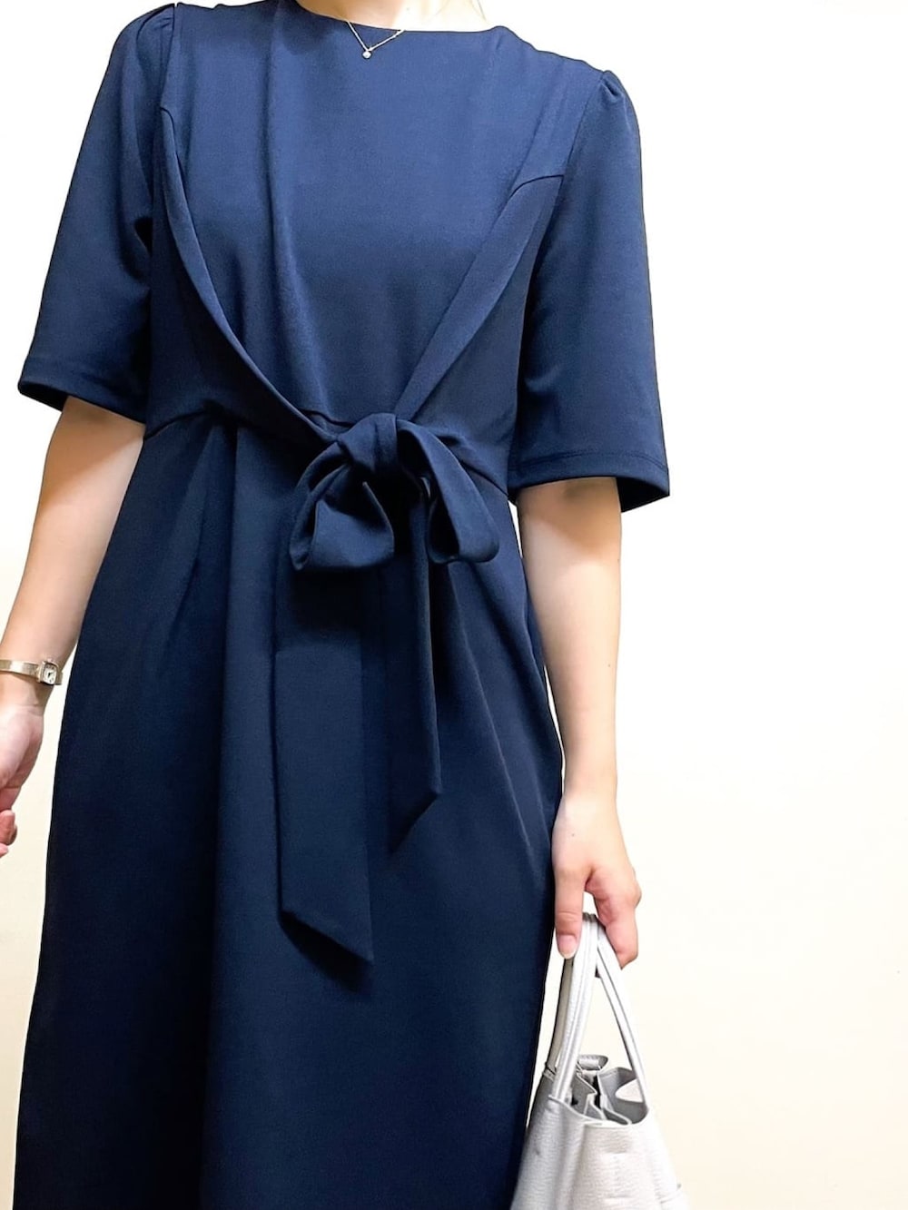 グレー系のトートバッグ、ブルー系のワンピース、ベージュ系のパンプスを着用したレディースの夏コーディネートの3枚目の写真