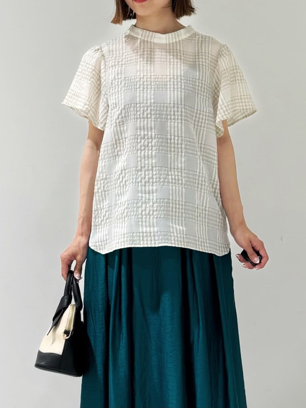 ブラック系のカーディガン/ボレロ、ベージュ系のシャツ/ブラウス、グリーン系のスカートを着用したレディースの夏コーディネートの9枚目の写真