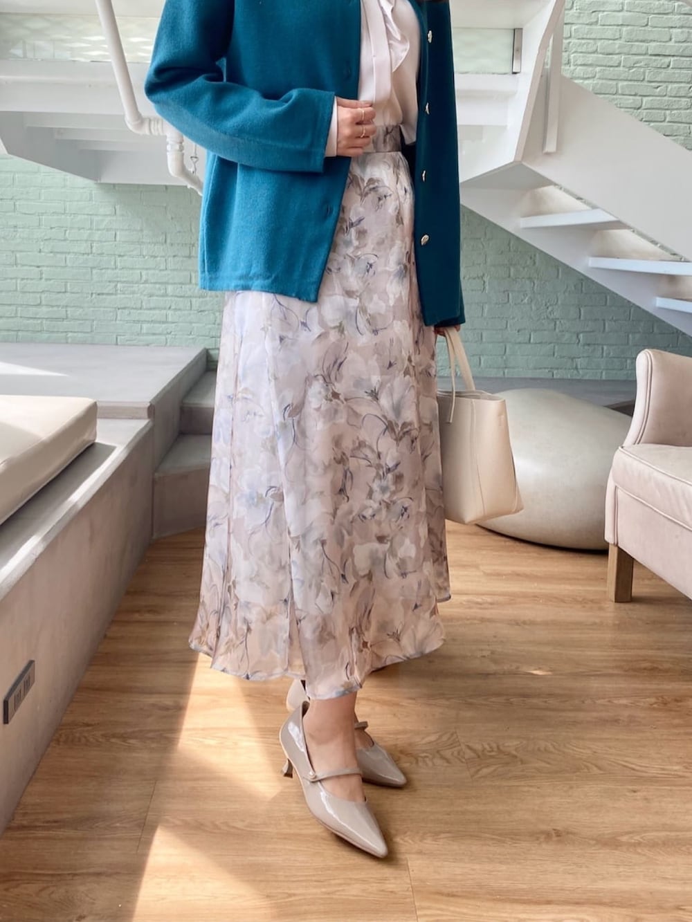 ブルー系のカーディガン/ボレロ、ベージュ系のシャツ/ブラウス、グレー系のスカートを着用したレディースの秋コーディネートの9枚目の写真