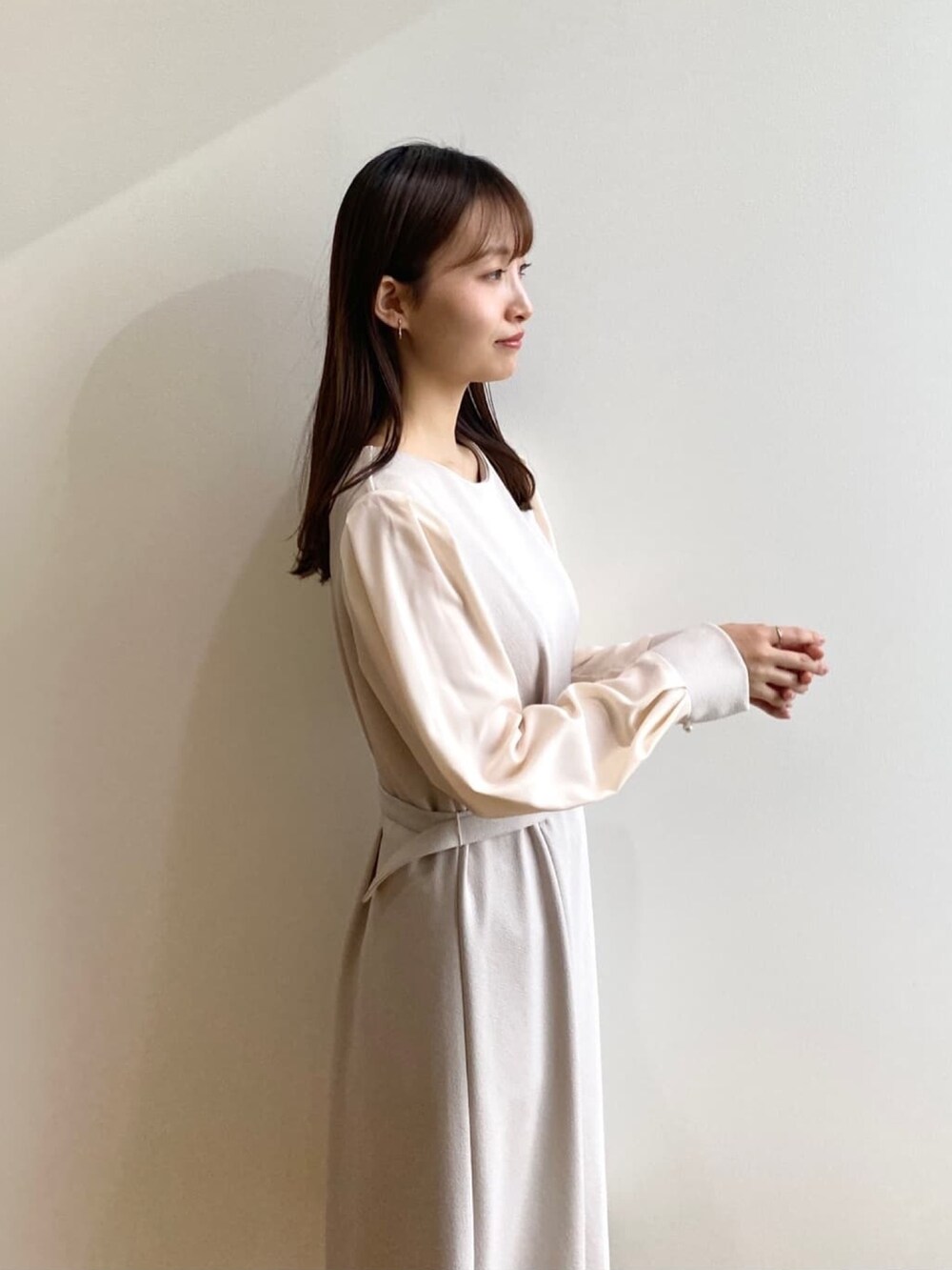 ベージュ系のワンピース、ホワイト系のパンプスを着用したレディースの冬コーディネートの5枚目の写真