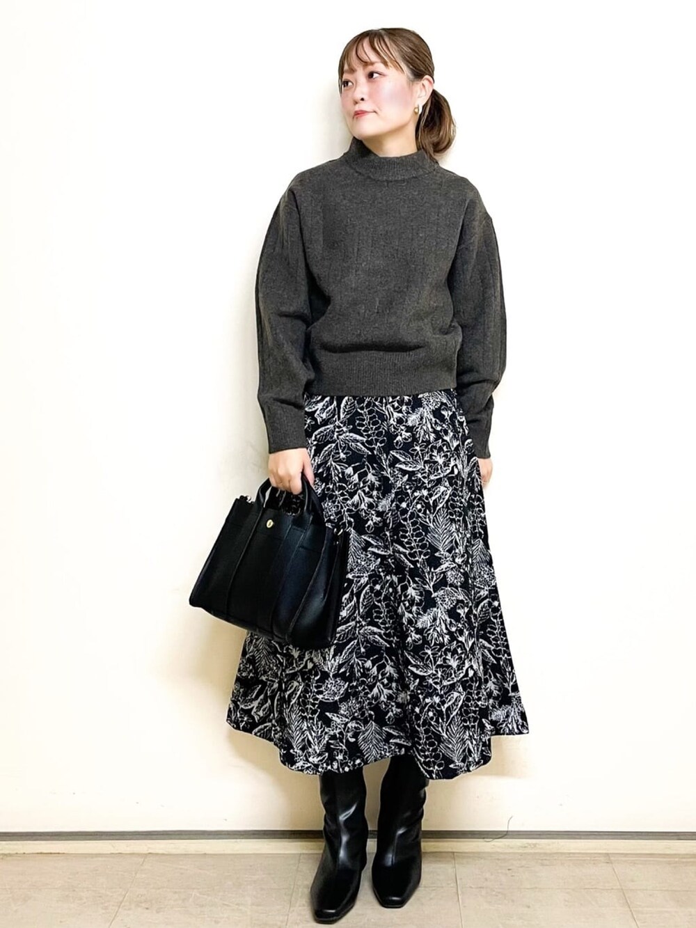 ブラウン系のニット/セーター、グレー系のダウンジャケット/コート、ブラック系のスカートを着用したレディースの冬コーディネートの4枚目の写真