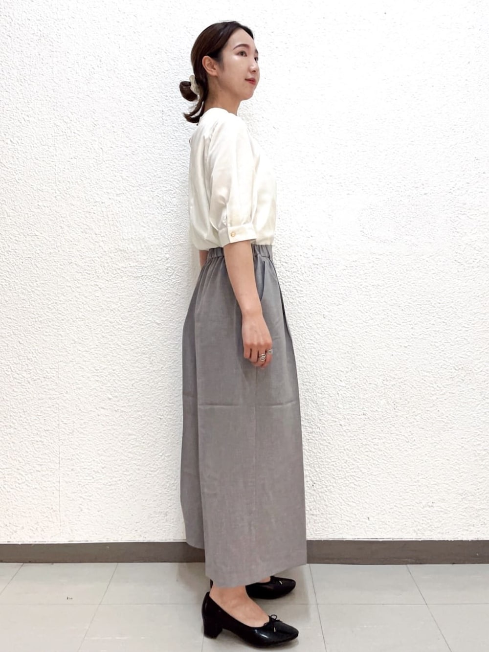 ホワイト系のシャツ/ブラウス、グレー系のその他パンツ、ブラック系のパンプスを着用したレディースの夏コーディネートの2枚目の写真