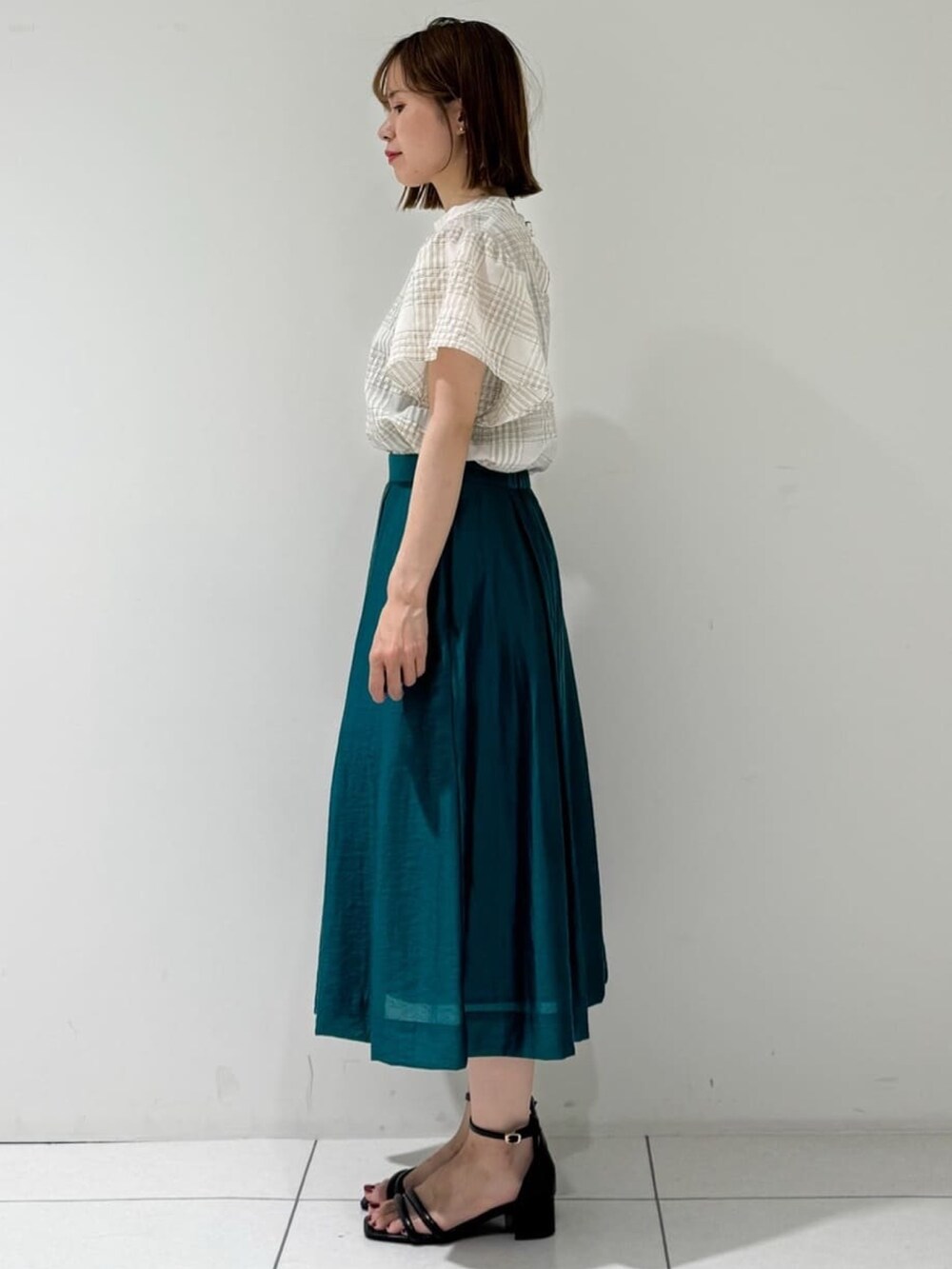 ブラック系のカーディガン/ボレロ、ベージュ系のシャツ/ブラウス、グリーン系のスカートを着用したレディースの夏コーディネートの6枚目の写真