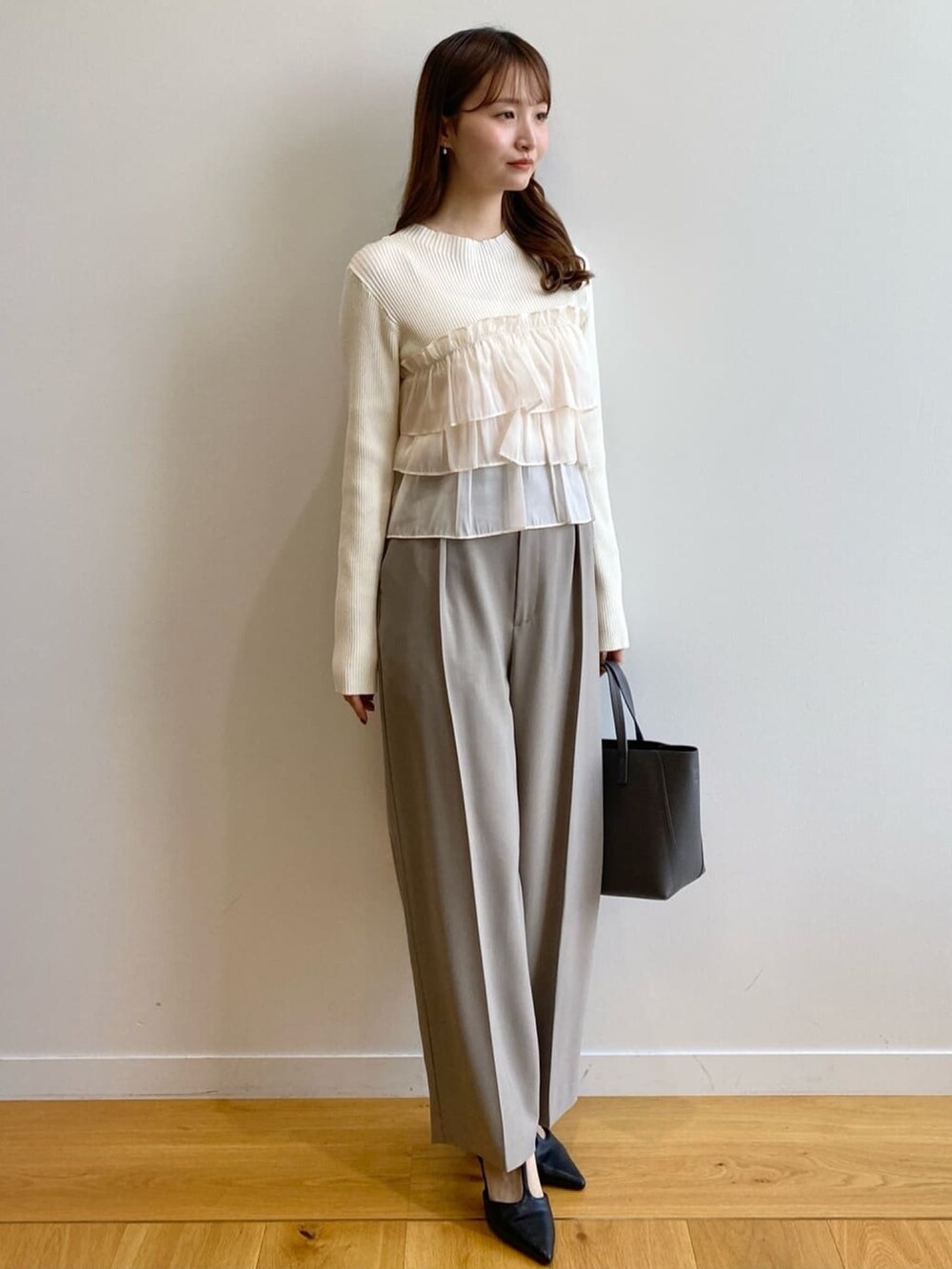 ホワイト系のニット/セーター、ベージュ系のその他パンツ、グレー系のトートバッグを着用したレディースの秋コーディネートの2枚目の写真