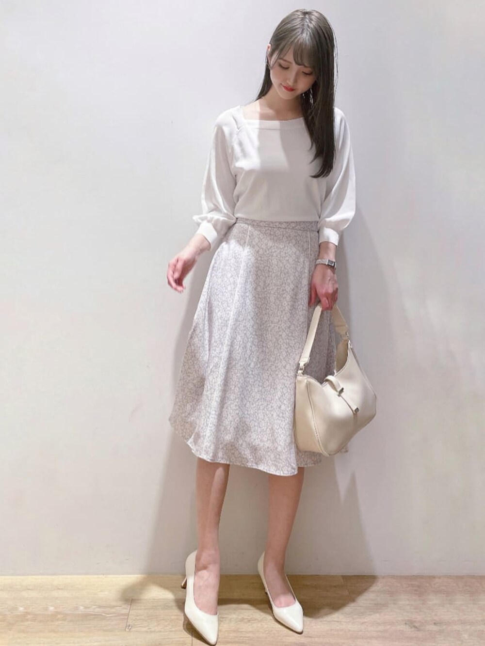 ホワイト系のニット/セーター、ホワイト系のパンプス、パープル系のスカートを着用したレディースの春コーディネートの2枚目の写真