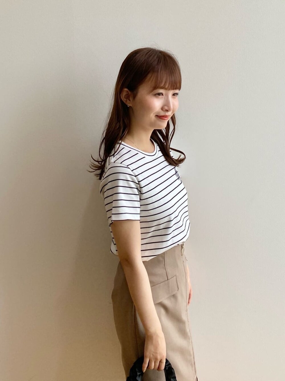 ホワイト系のTシャツ/カットソー、ブラウン系のスカート、ブラック系のトートバッグを着用したレディースの夏コーディネートの8枚目の写真