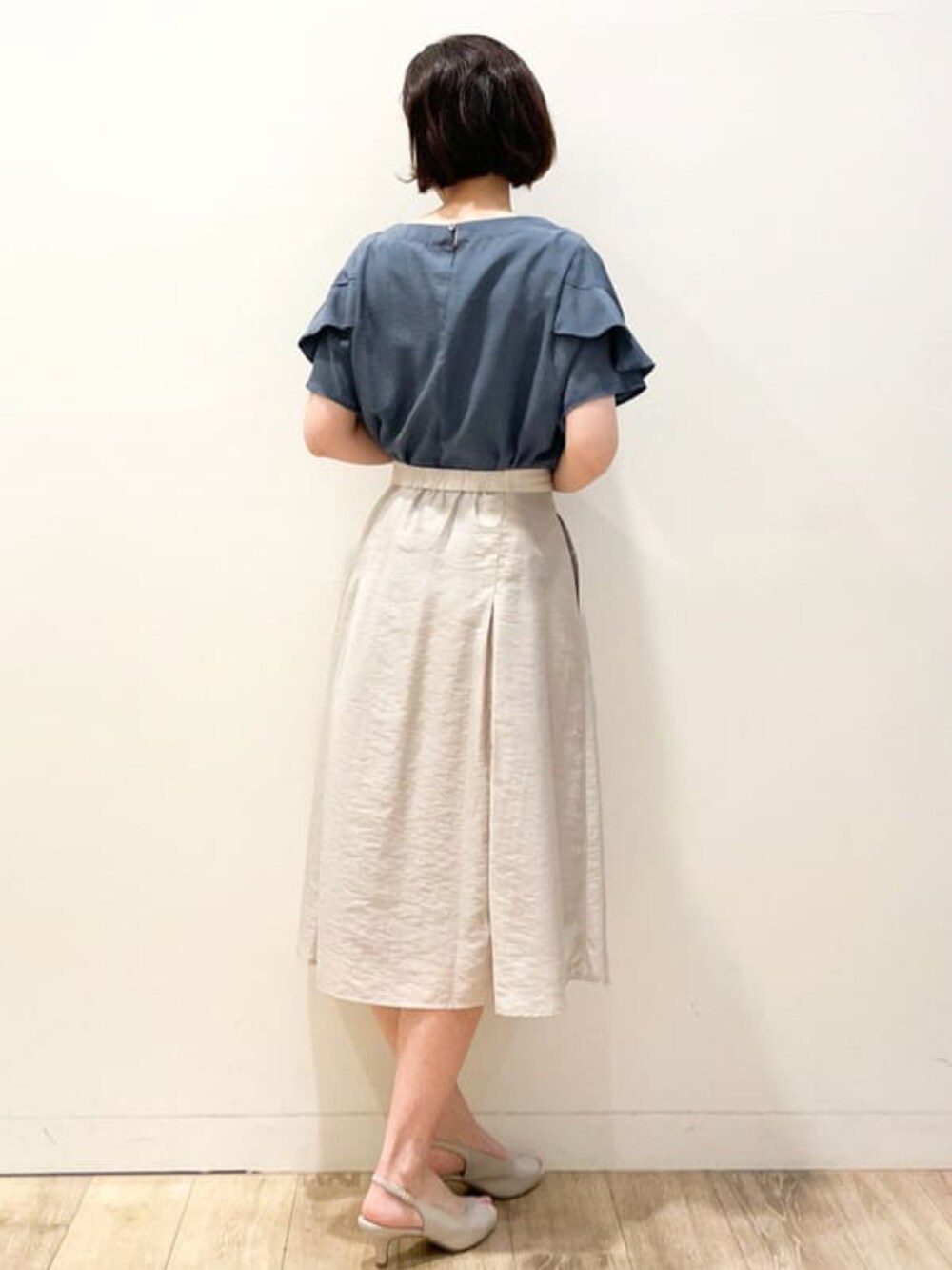 ブルー系のシャツ/ブラウス、グレー系のスカート、ホワイト系のショルダーバッグを着用したレディースの夏コーディネートの2枚目の写真