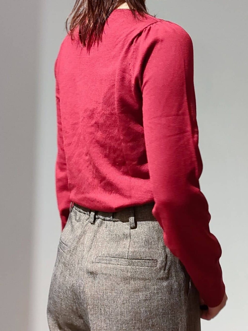 レッド系のニット/セーター、ブラウン系のその他パンツ、ブラック系のショルダーバッグを着用したレディースの秋コーディネートの6枚目の写真