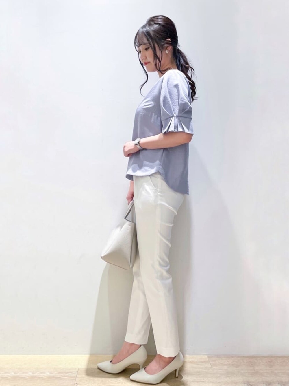 ブルー系のシャツ/ブラウス、ホワイト系のパンプス、グレー系のトートバッグを着用したレディースの春コーディネートの2枚目の写真