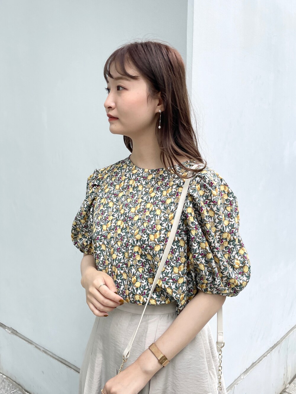 グレー系のスカート、ホワイト系のサンダル、ホワイト系のショルダーバッグを着用したレディースの夏コーディネートの4枚目の写真