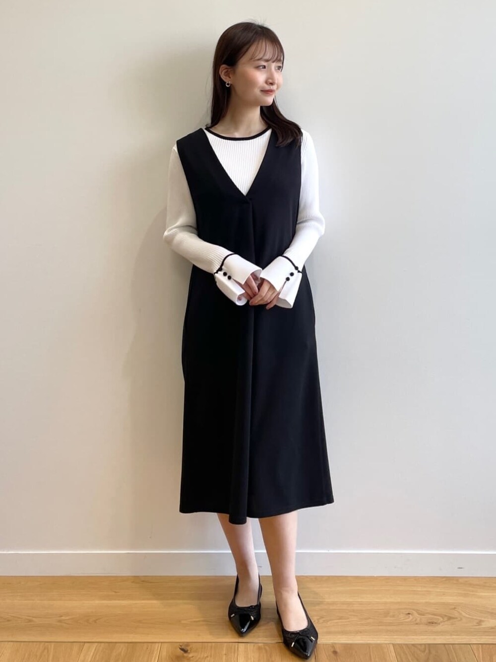 ホワイト系のニット/セーター、ブラック系のスカート、ブラック系のその他シューズを着用したレディースの春コーディネートの6枚目の写真