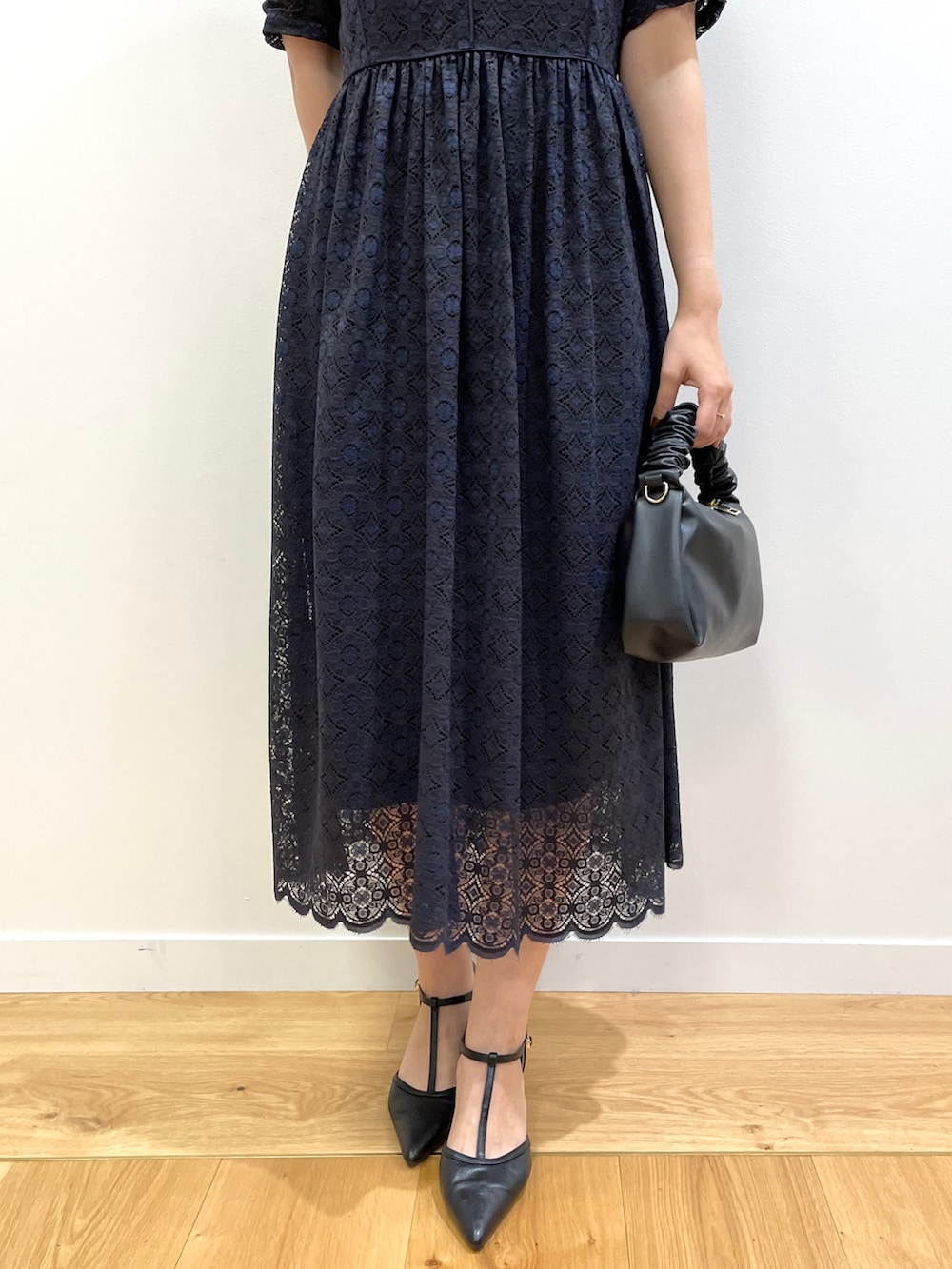 ブルー系のワンピース、ブラック系のショルダーバッグ、ブラック系のパンプスを着用したレディースの秋コーディネートの5枚目の写真