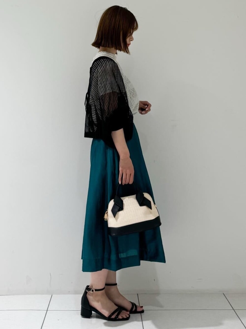 ブラック系のカーディガン/ボレロ、ベージュ系のシャツ/ブラウス、グリーン系のスカートを着用したレディースの夏コーディネートの4枚目の写真