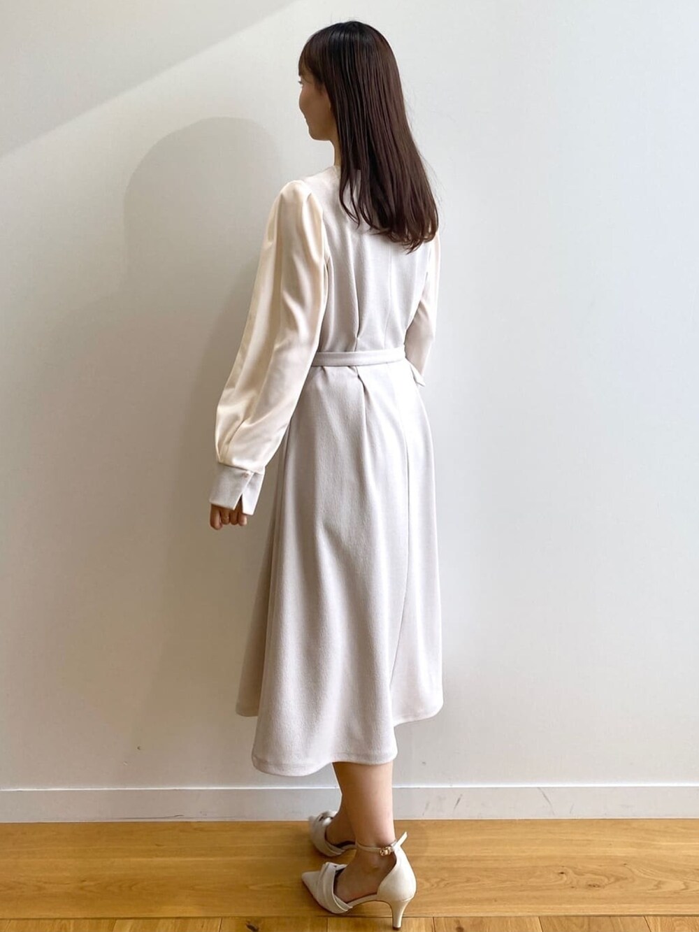 ベージュ系のワンピース、ホワイト系のパンプスを着用したレディースの冬コーディネートの4枚目の写真