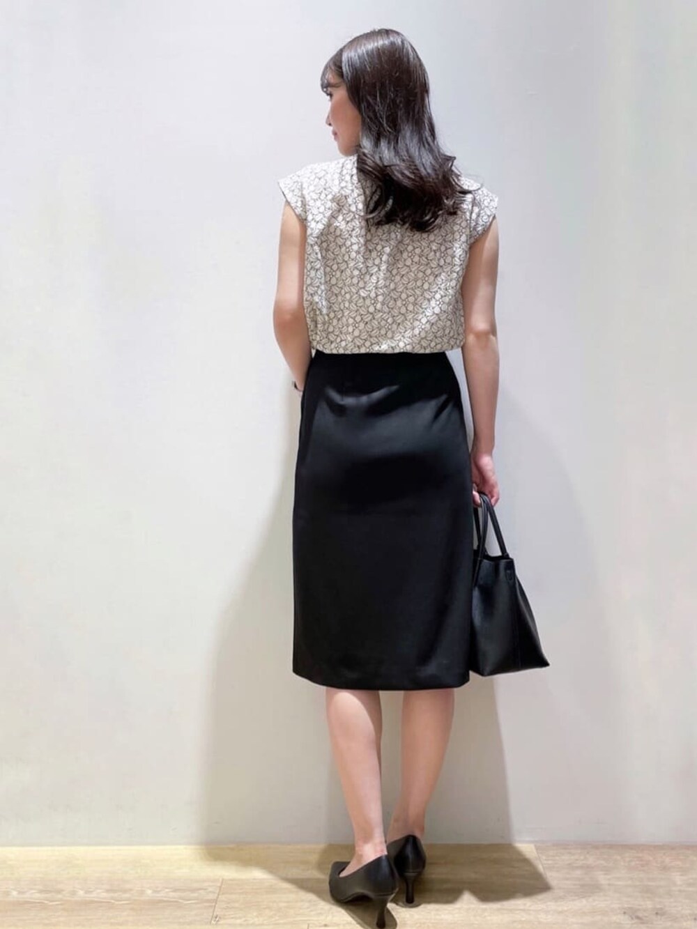 ブラック系のスカート、ホワイト系のシャツ/ブラウス、ブラック系のトートバッグを着用したレディースの秋コーディネートの3枚目の写真