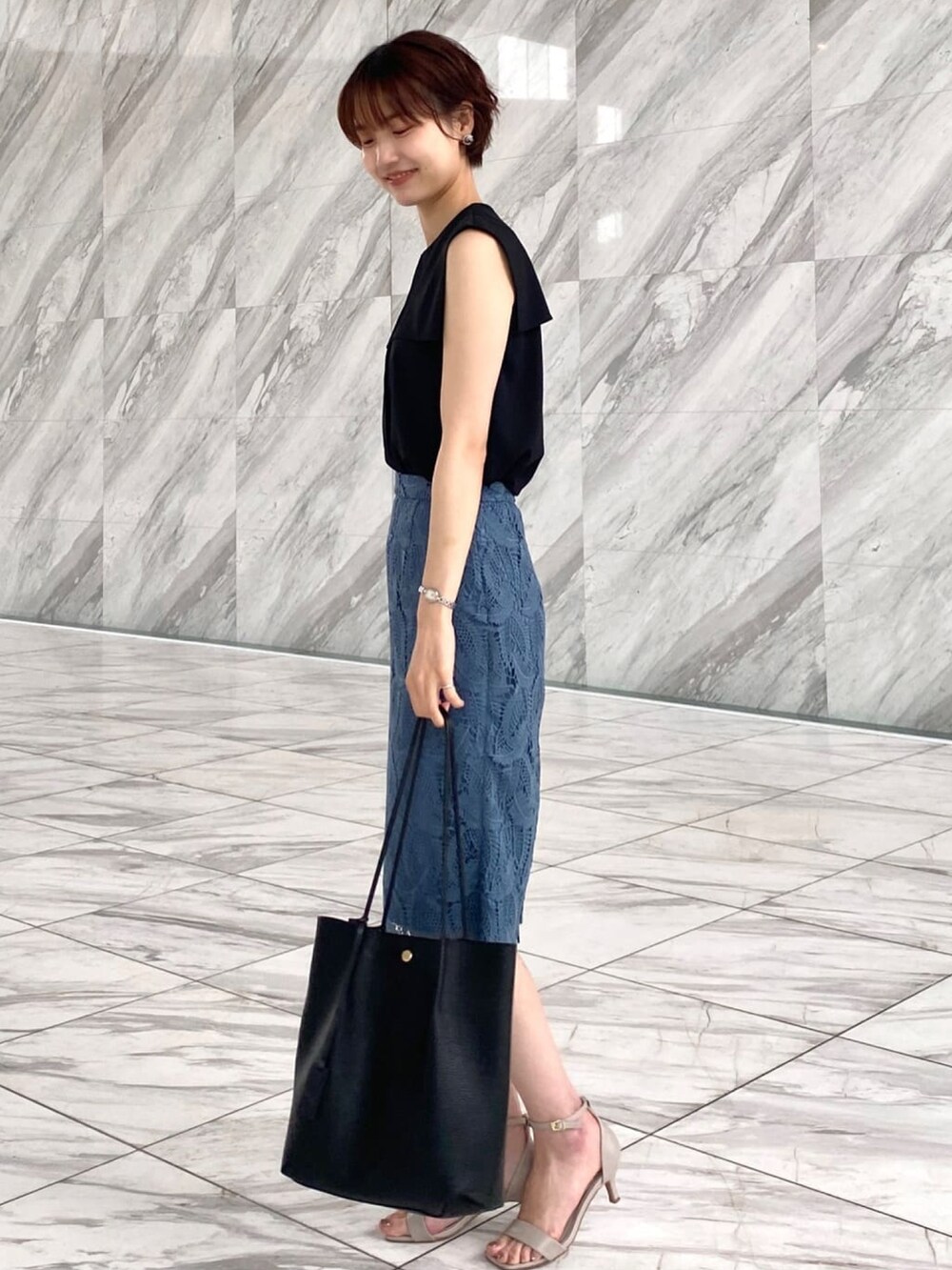 ブラック系のシャツ/ブラウス、ブルー系のスカート、ブラック系のトートバッグを着用したレディースの夏コーディネートの2枚目の写真