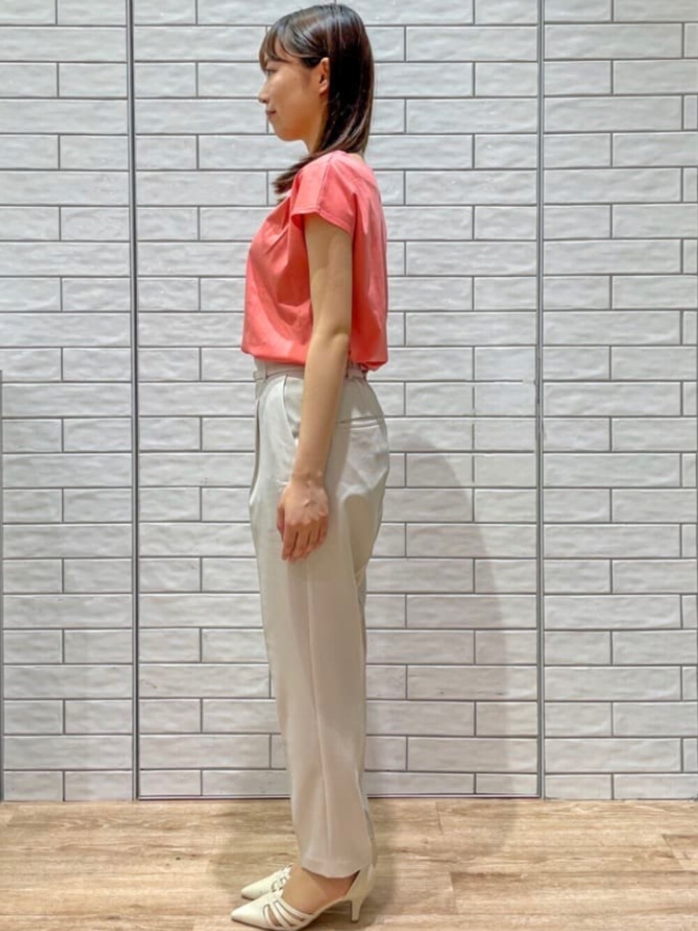 オレンジ系のTシャツ/カットソー、ベージュ系のその他パンツ、ホワイト系のパンプスを着用したレディースの夏コーディネートの3枚目の写真