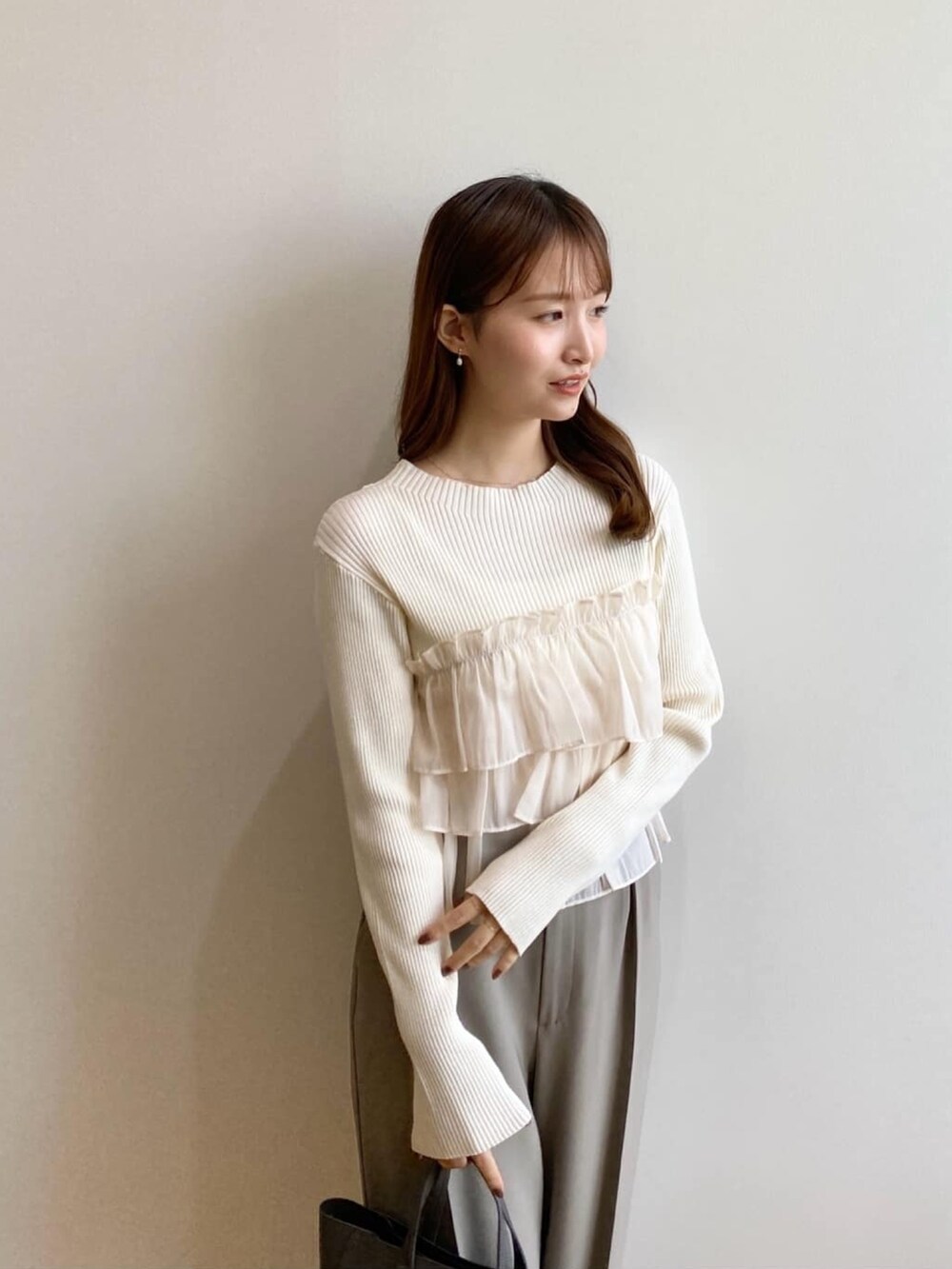 ホワイト系のニット/セーター、ベージュ系のその他パンツ、グレー系のトートバッグを着用したレディースの秋コーディネートの6枚目の写真