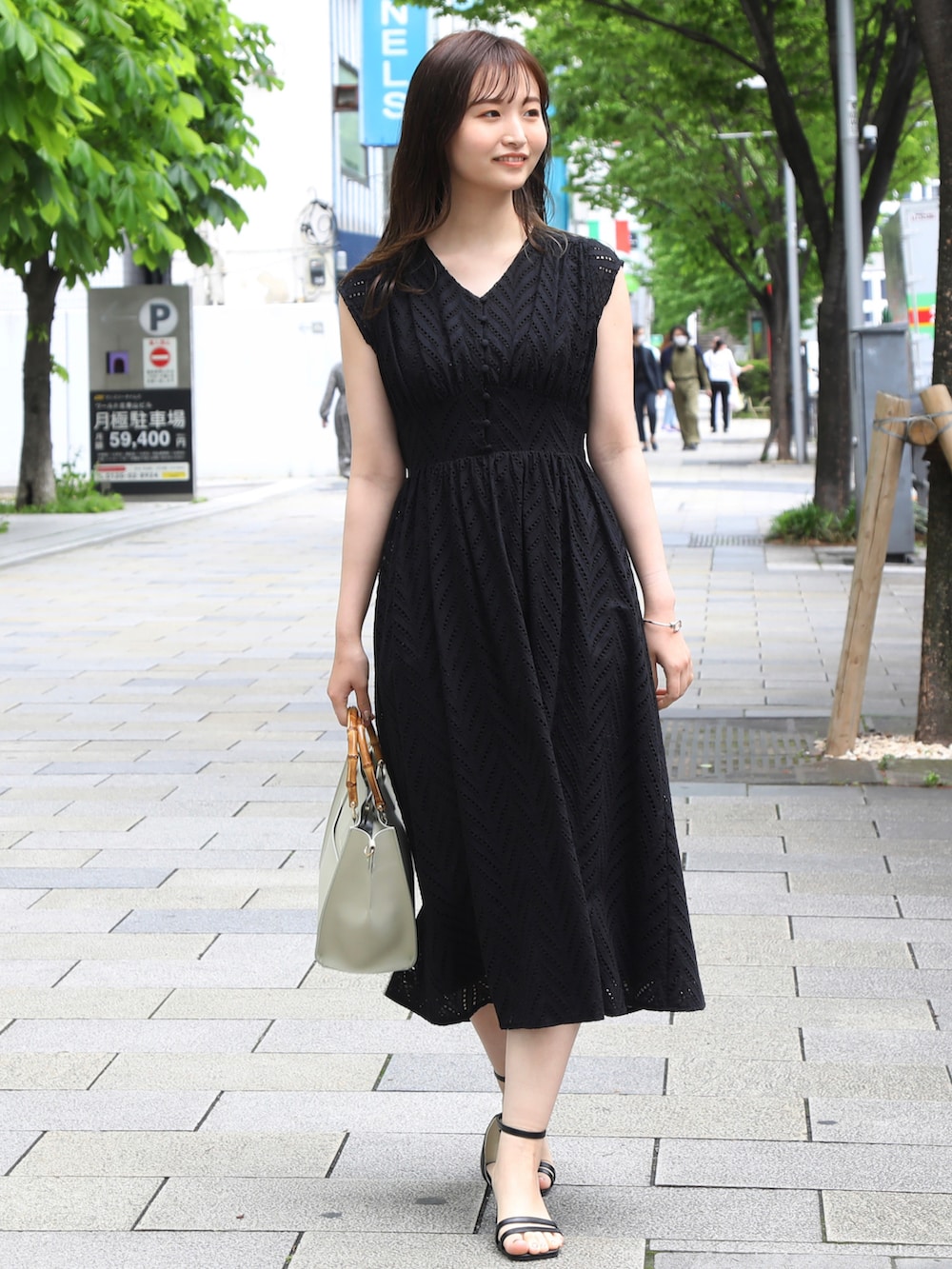 ホワイト系のカーディガン/ボレロ、ブラック系のワンピース、ブラック系のサンダルを着用したレディースの春コーディネートの2枚目の写真