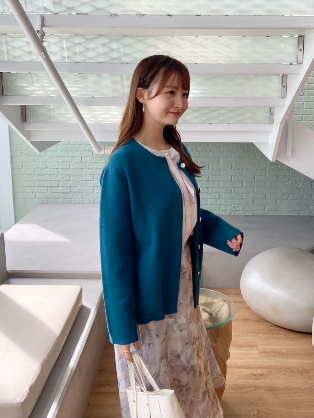 ブルー系のカーディガン/ボレロ、ベージュ系のシャツ/ブラウス、グレー系のスカートを着用したレディースの秋コーディネートの6枚目の写真