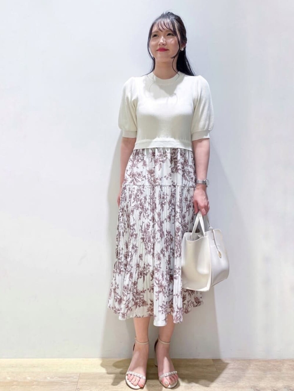 ベージュ系のサンダル、ホワイト系のワンピース、ホワイト系のトートバッグを着用したレディースの夏コーディネートの2枚目の写真