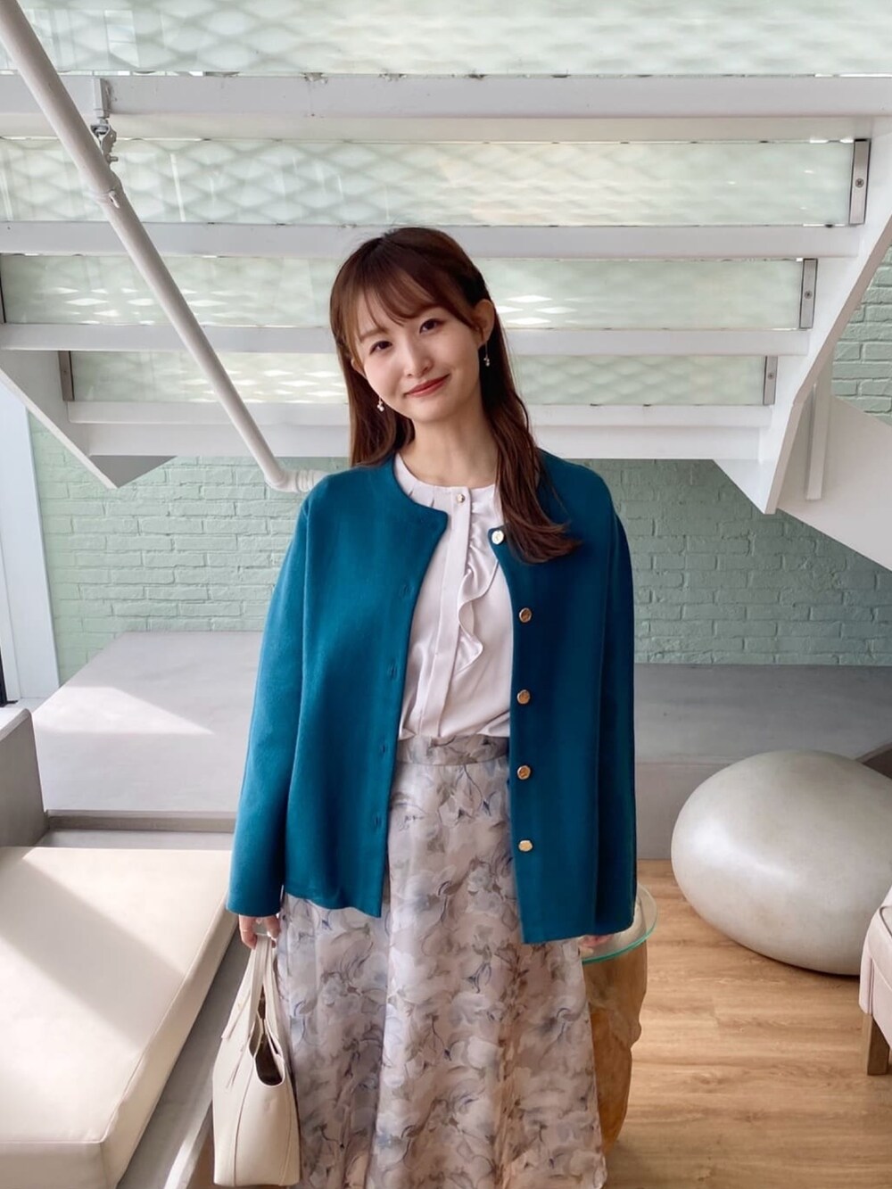 ブルー系のカーディガン/ボレロ、ベージュ系のシャツ/ブラウス、グレー系のスカートを着用したレディースの秋コーディネートの7枚目の写真