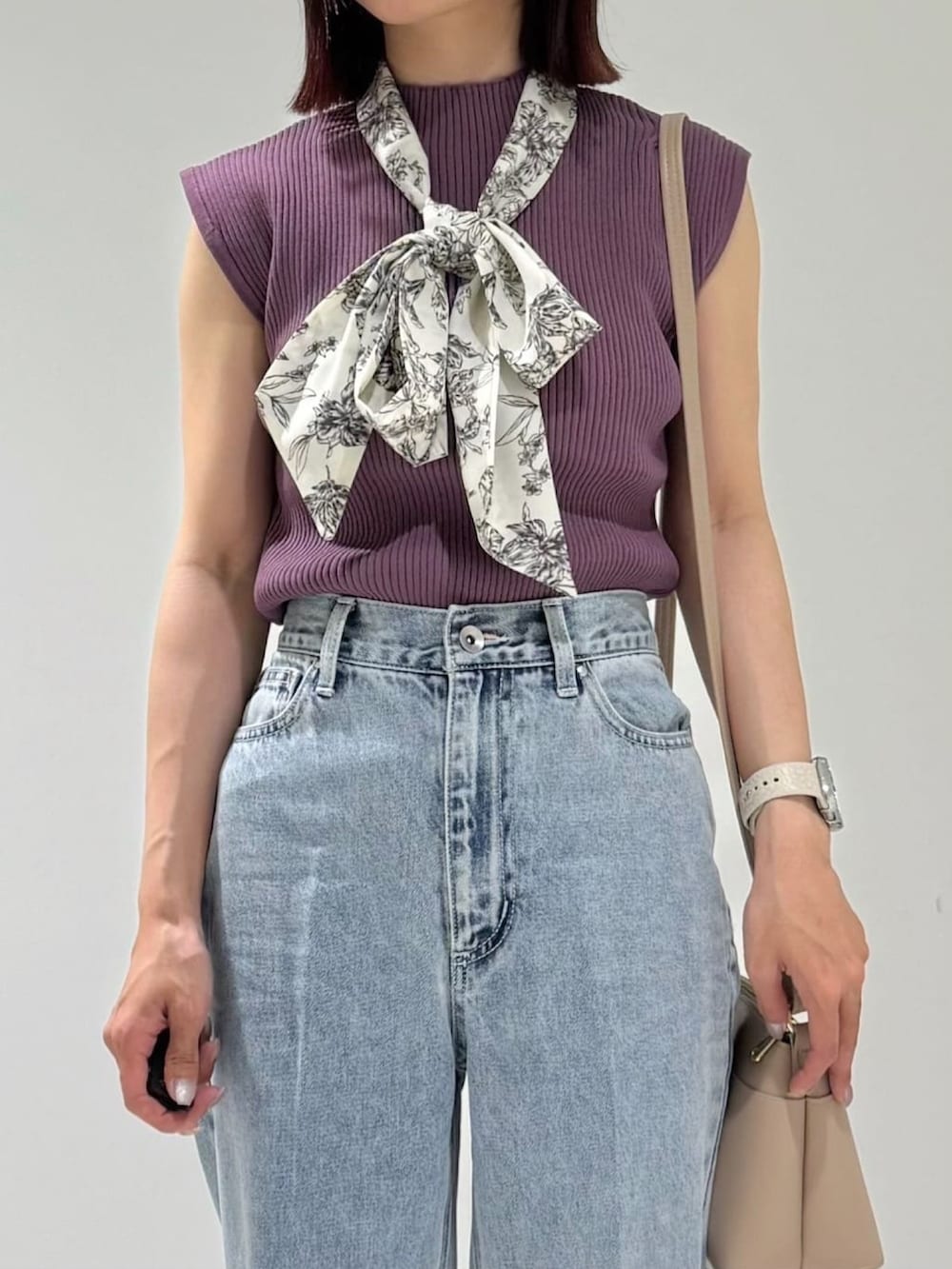 パープル系のニット/セーター、ベージュ系のショルダーバッグ、ブルー系のデニムパンツを着用したレディースの夏コーディネートの3枚目の写真