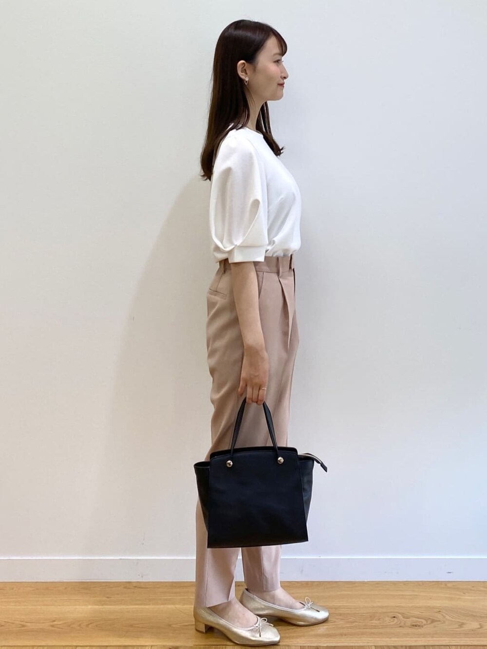 イエロー系のその他パンツ、ブラック系のハンドバッグ、ゴールド系のパンプスを着用したレディースの春コーディネートの2枚目の写真