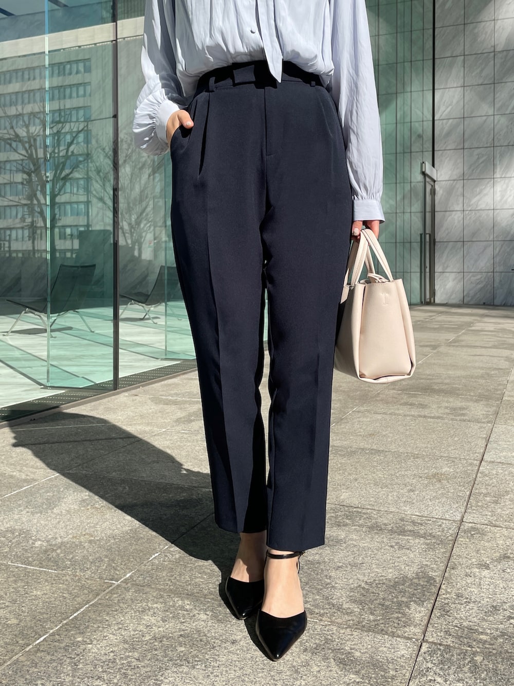 ブルー系のスーツパンツ、ブルー系のシャツ/ブラウス、ベージュ系のショルダーバッグを着用したレディースの冬コーディネートの3枚目の写真