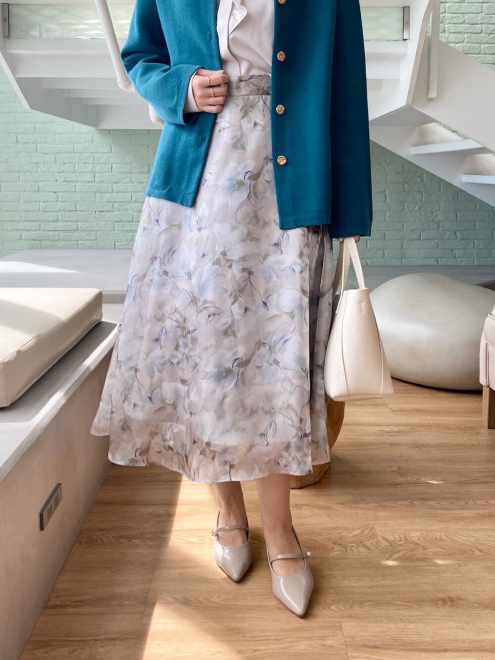 ブルー系のカーディガン/ボレロ、ベージュ系のシャツ/ブラウス、グレー系のスカートを着用したレディースの秋コーディネートの8枚目の写真