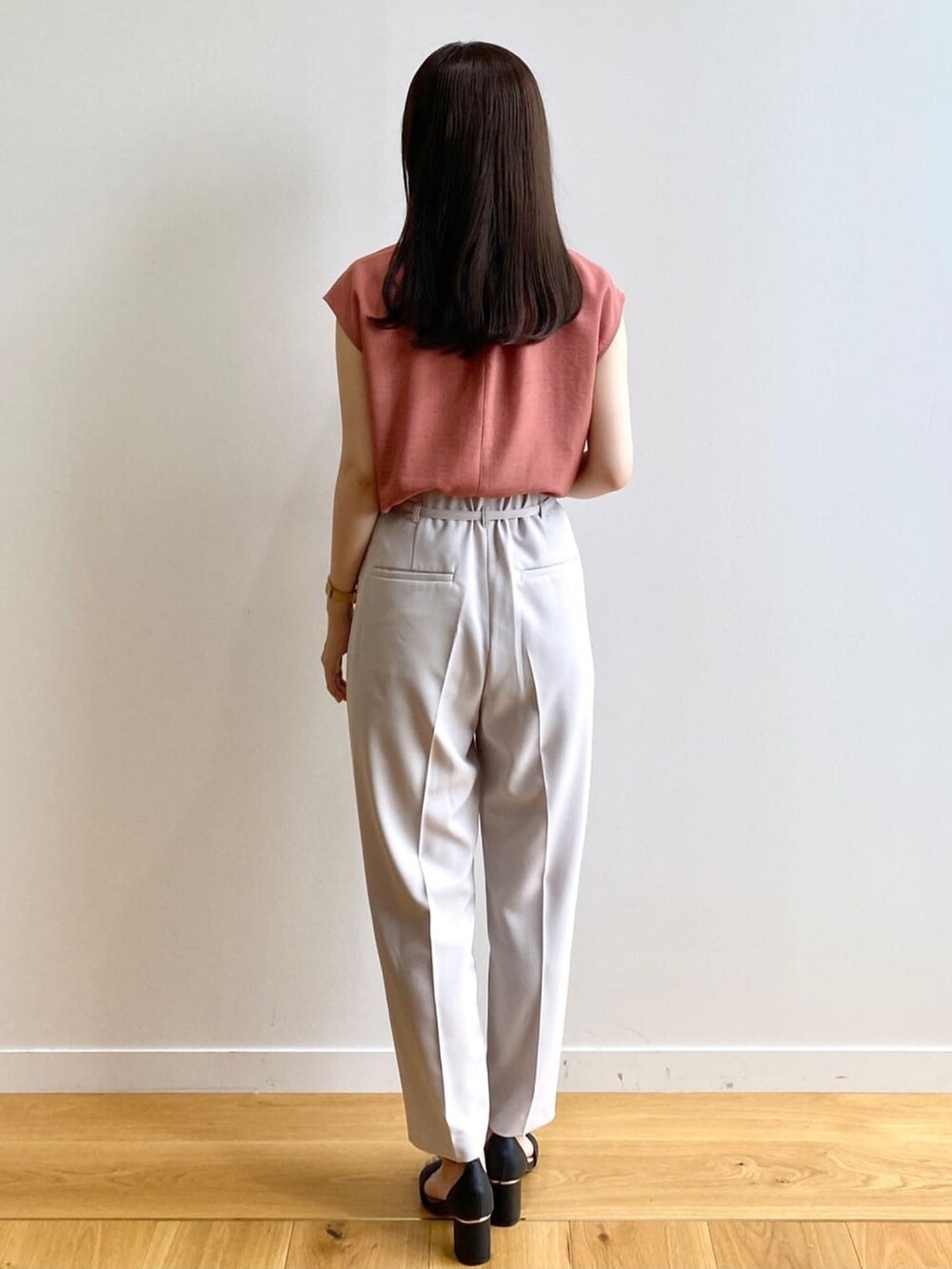 グレー系のその他パンツ、オレンジ系のシャツ/ブラウス、ブラック系のサンダルを着用したレディースの夏コーディネートの3枚目の写真