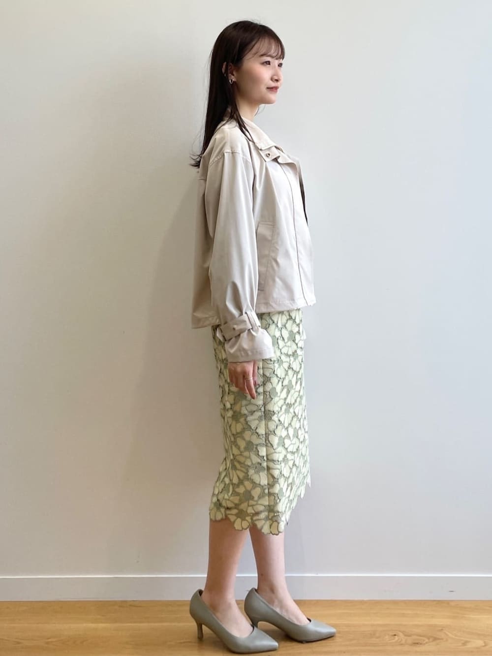 イエロー系のスカート、ブルー系のTシャツ/カットソー、グリーン系のパンプスを着用したレディースの春コーディネートの2枚目の写真