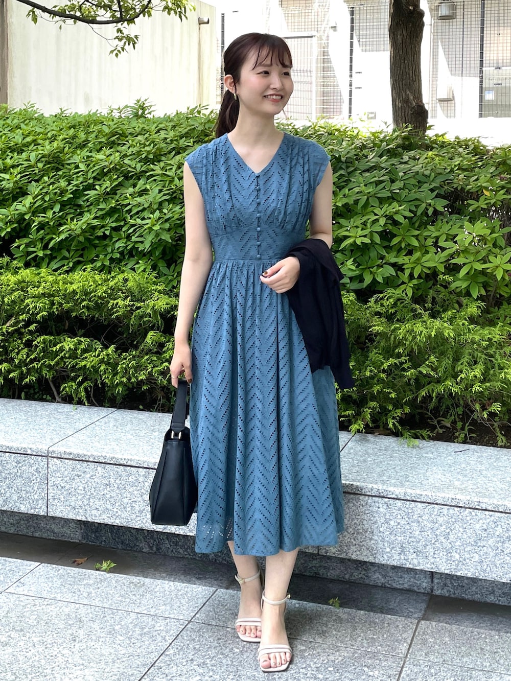 ブルー系のワンピース、ブラック系のカーディガン/ボレロ、ブラック系のショルダーバッグを着用したレディースの春コーディネートの2枚目の写真