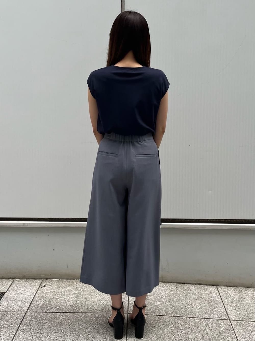 グレー系のその他パンツ、ブルー系のTシャツ/カットソー、ブラック系のサンダルを着用したレディースの春コーディネートの3枚目の写真