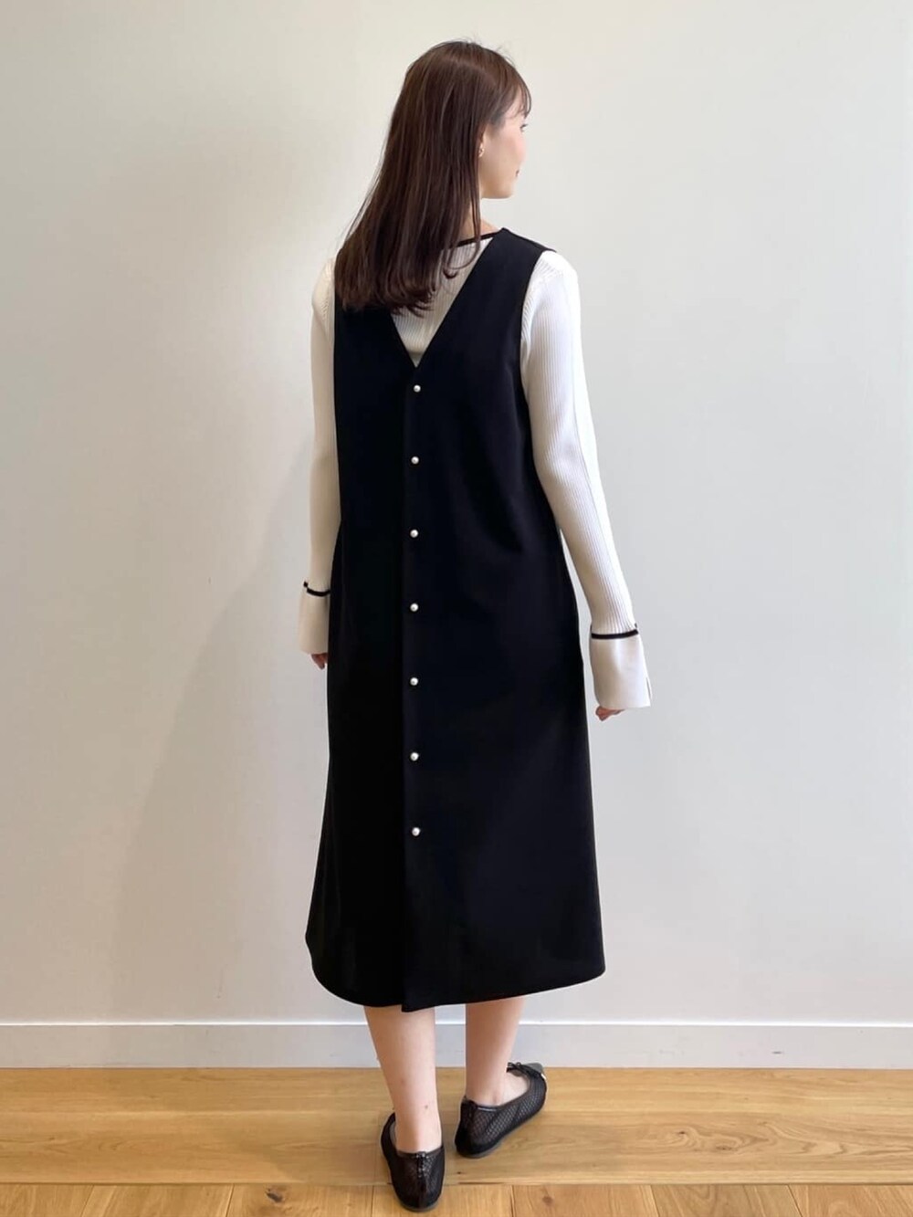 ホワイト系のニット/セーター、ブラック系のスカート、ブラック系のその他シューズを着用したレディースの春コーディネートの7枚目の写真