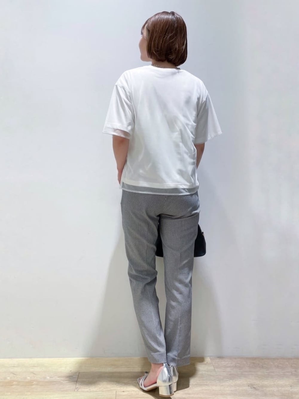 ホワイト系のTシャツ/カットソー、ブラック系のショルダーバッグ、ブラック系のその他パンツを着用したレディースの夏コーディネートの3枚目の写真