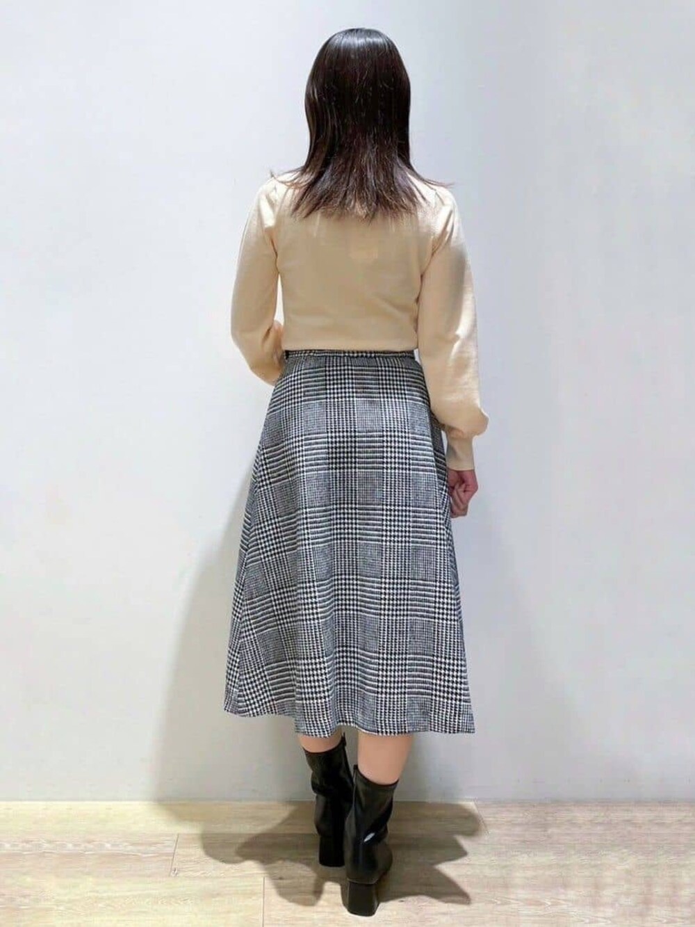 ブラック系のスカート、オレンジ系のニット/セーター、ブラック系のトートバッグを着用したレディースの冬コーディネートの3枚目の写真