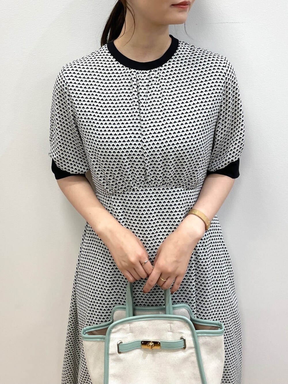 ベージュ系のワンピース、グリーン系のトートバッグ、その他のパンプスを着用したレディースの夏コーディネートの2枚目の写真