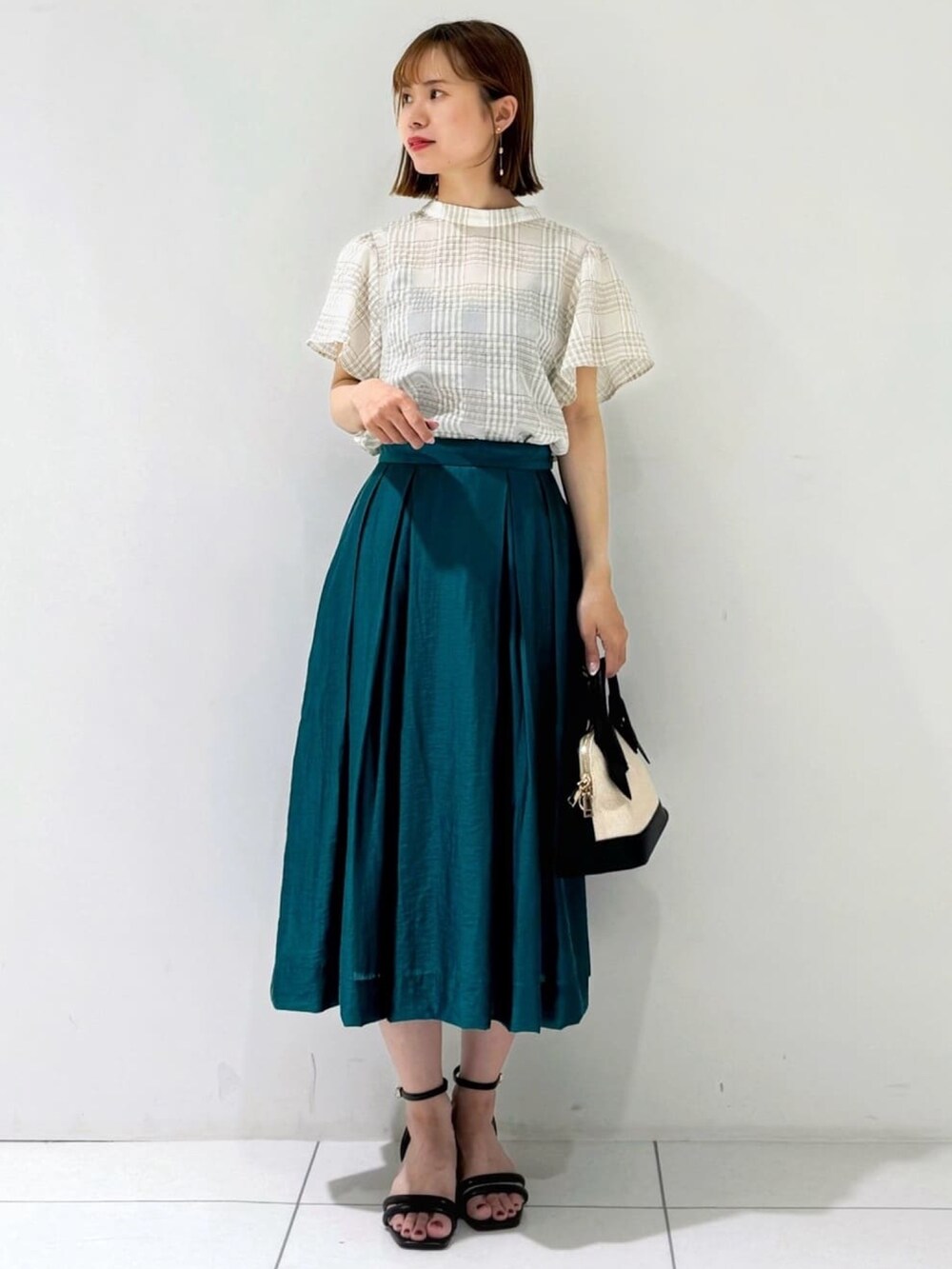 ブラック系のカーディガン/ボレロ、ベージュ系のシャツ/ブラウス、グリーン系のスカートを着用したレディースの夏コーディネートの5枚目の写真